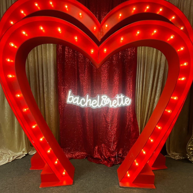 Red marquee heart arch with lit bachelorette neon sign